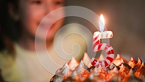 The girl blows out a burning candle with the number 5 on the cake and makes a wish. Birthday, fifth anniversary, five years, candl