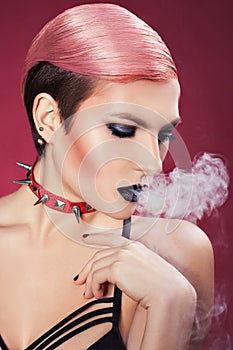 Girl blows smoke.