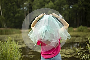 Girl in blue cape on her head. Transparent fabric at bridesmaid& x27;s. Blue veil on girl