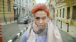 Girl in a blue coat posing at the camera, walking around the city