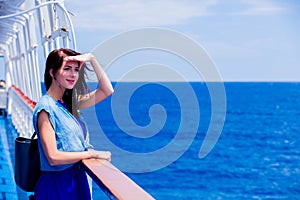 Girl in blue dress and hat have a voyage on a boat