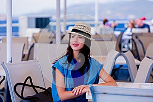 Girl in blue dress and hat have a voyage on a boat