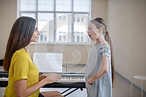Girl in a blue dress having a vocal lesson