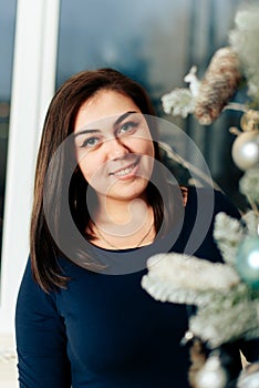 Girl in a blue dress in a New Year decor near a decorated Christmas tree