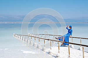 Girl in a blue dress on the shores of the dead sea in Israel on a sunny day