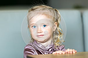 A girl with blue eyes near green grass.