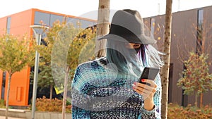 girl with blue hair in Protective black Mask and hat with smartphone. Urban fashion outfit.
