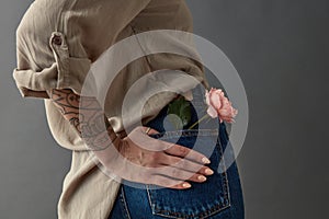 A girl in blue jeans with a pink rose