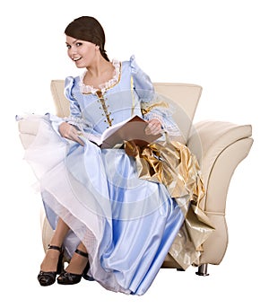 Girl in blue lond dress with book on chair.