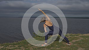 Girl in blue sportswear, yogi practice outdoor.