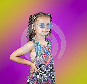 Girl in blue sunglasses on rainbow background