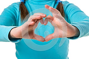 Girl in blue sweater with hands in heart shape close up