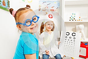 Girl in blue toy glasses at ophthalmologist room