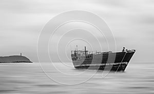 Girl on board the old ship watching and waiting for someone. Long exposure black and white photo