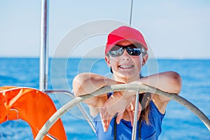 Girl on board of sailing yacht on summer cruise. Travel adventure, yachting with child on family vacation.