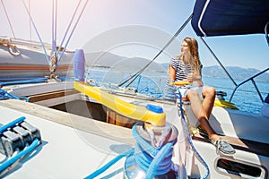 Girl on board of sailing yacht on summer cruise. Travel adventure, yachting with child on family vacation. photo