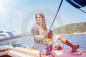 Girl on board of sailing yacht on summer cruise. Travel adventure, yachting with child on family vacation. photo