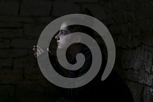 Girl in a bomb shelter prays to God for peace in her country photo