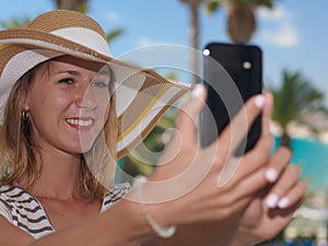 Girl in bonnet hat making selfie against beautiful sea view photo