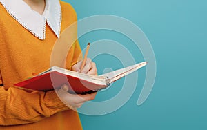 Girl with book on background of bright teal wall