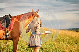 Girl with book in the field. woman walking with horse
