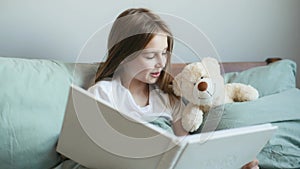 Girl with book and teddy bear