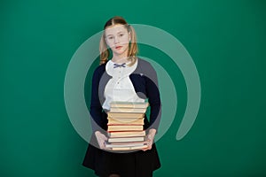 Girl with books from school boards in the classroom lesson