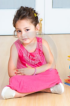 girl with books sitting on the floor in kindergarten