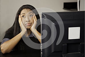 Girl bored at computer.