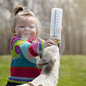 Girl bottle feeding lamb