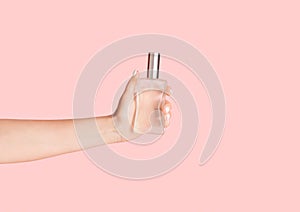 Girl with bottle of natural perfume on pink background, closeup