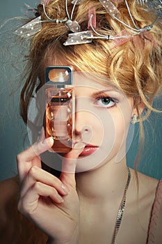 Girl with a bottle of perfume about her face