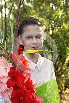 Girl with a bouquet of gladioli on the first day of school