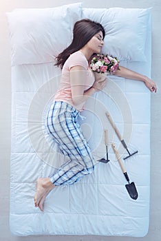Girl with bouquet taking nap after working in garden