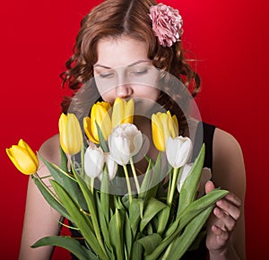 Girl with a bouquet of tulips on red background