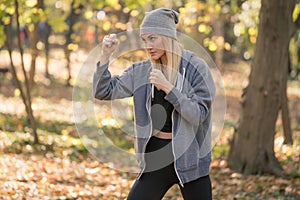 Girl boxer doing uppercut kick working out outdoors