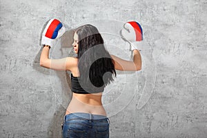 Girl in boxing gloves, topic leaned to wall
