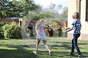 A girl and a boy in a comic battle on water pistols