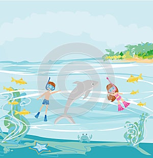 Girl and boy are diving with a dolphin