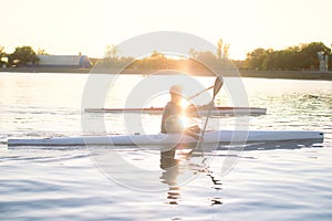 The girl or boy is engaged in rowing sitting in a boat rowing oars in rafting