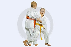 Girl and boy in judogi are training throwing