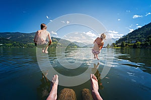 Girl and boy jumping in lake water
