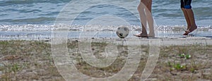 Girl and boy playing football at the beach