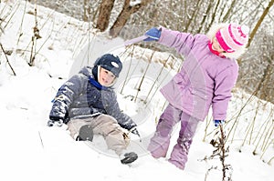 Girl and boy playing at snowy winter