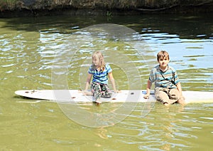 Girl and boy playing on surf