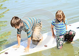 Girl and boy playing on surf