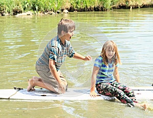 Girl and boy playing on surf