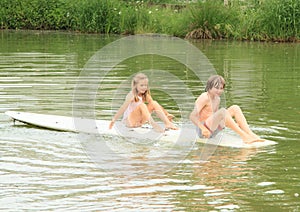 Girl and boy sitting on surf