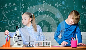 Girl and boy smart students conduct school experiment. Describe chemical reaction notepad. School education. Chemical
