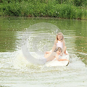 Girl and boy splashing on surf